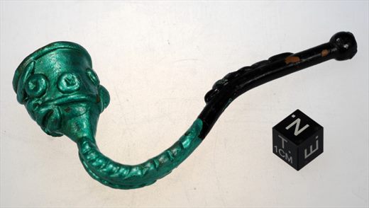Cachimbo metalico verde e preto com rosto estilizado